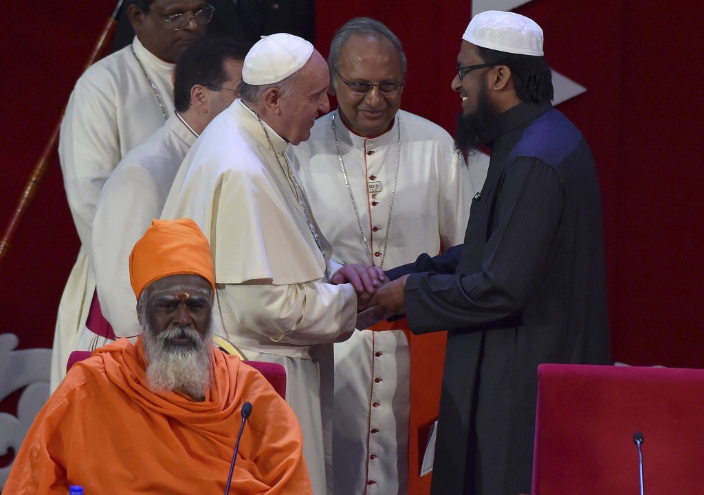 PAP34 COLOMBO (SRI LANKA), 13/01/2015.- El papa Francisco (i) da la mano al jeque musulmán M.F.M Fazil (d) durante un encuentro interreligioso que ha tenido lugar en el centro de congresos Bandaranaike en Colombo, Sri Lanka, hoy, martes 13 de enero de 2015. En el encuentro se dieron cita los representantes de las diferentes religiones que conviven en el país: budistas, hindúes, musulmanes y comunidades cristianas. El papa estará de visita en Sri Lanka y Filipinas hasta el próximo 19 de enero. EFE/ETTORE FERRARI